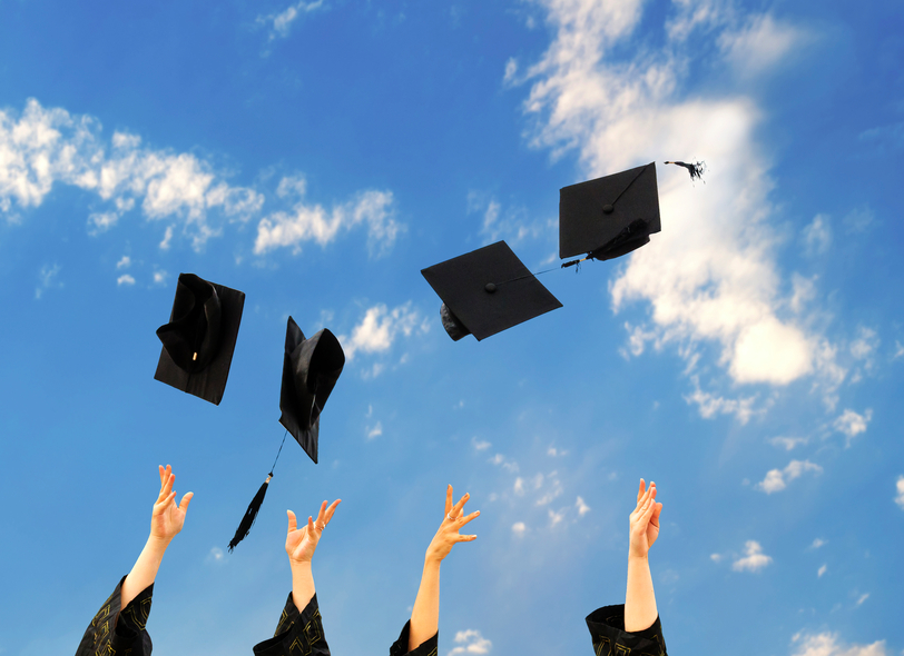 graduates throwing graduation hats in the air.